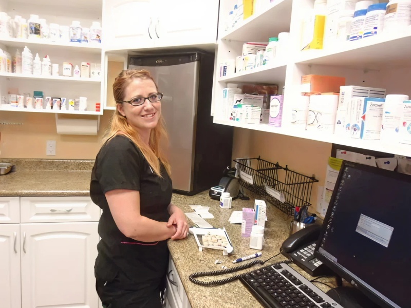 Veterinarian standing in pharmacy area.